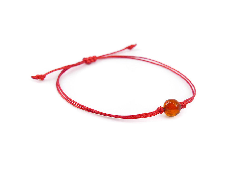 PULSERA DE HILO ROJO CON ÁMBAR BÁLTICO PULIDO EN COLOR COÑAC