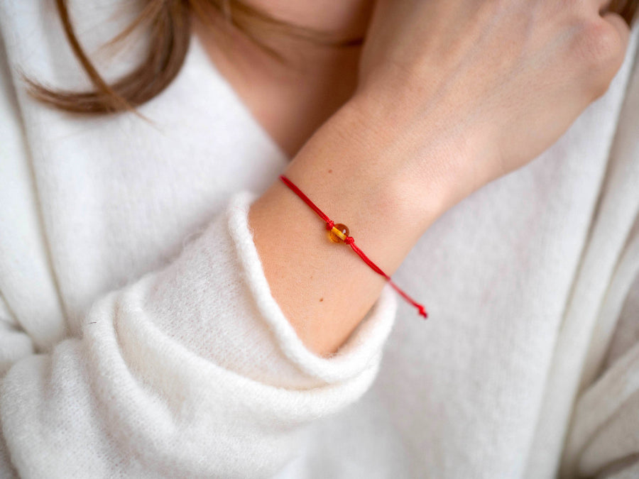 PULSERA DE HILO ROJO CON ÁMBAR BÁLTICO PULIDO EN COLOR MIEL