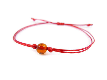 PULSERA DE HILO ROJO CON ÁMBAR BÁLTICO PULIDO EN COLOR COÑAC