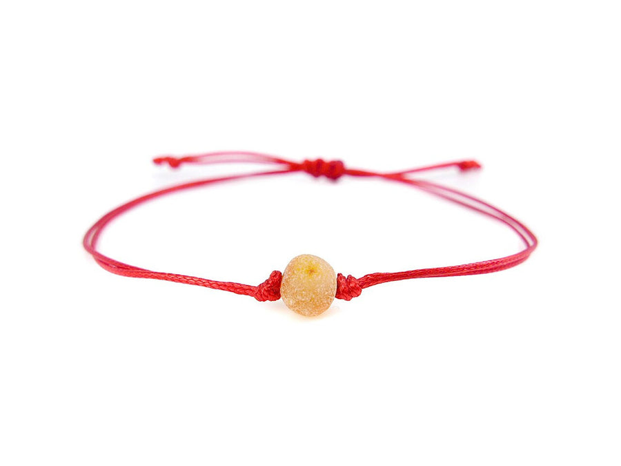 PULSERA DE HILO ROJO CON ÁMBAR BÁLTICO CRUDO EN COLOR MIEL