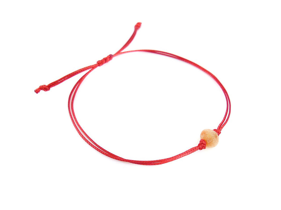 PULSERA DE HILO ROJO CON ÁMBAR BÁLTICO CRUDO EN COLOR MIEL