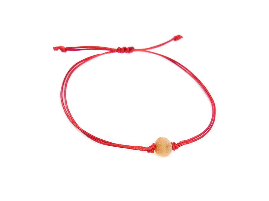 PULSERA DE HILO ROJO CON ÁMBAR BÁLTICO CRUDO EN COLOR MIEL