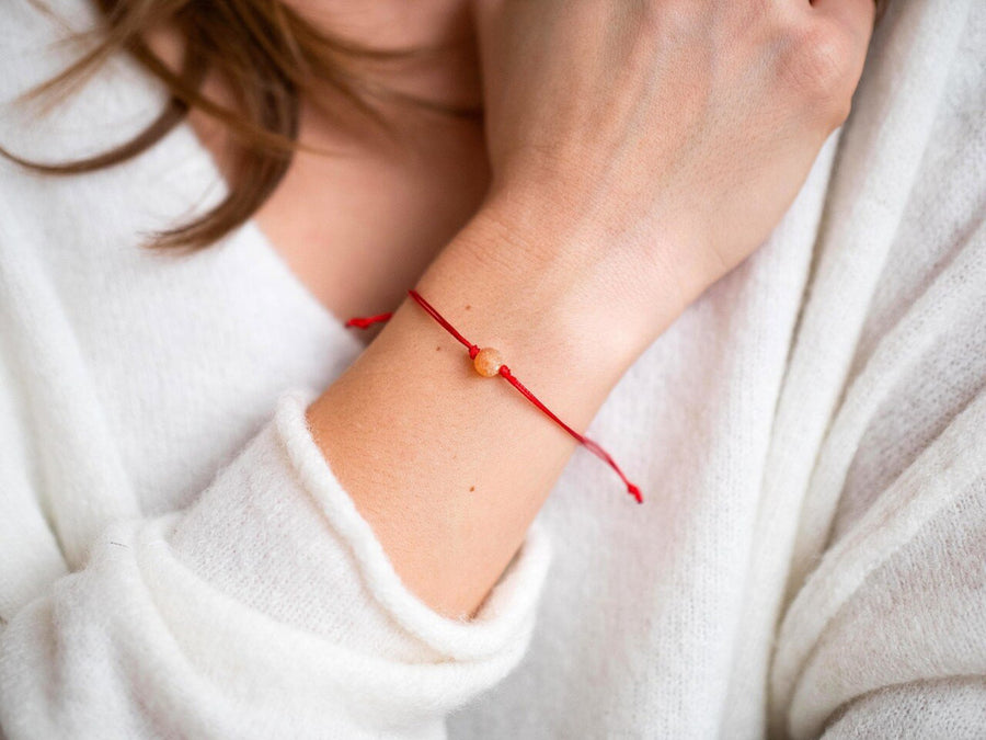 PULSERA DE HILO ROJO CON ÁMBAR BÁLTICO CRUDO EN COLOR MIEL